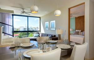 a dining room with a table and chairs and a living room at Anah Suites by Las Flores Vacation Rentals in Playa del Carmen
