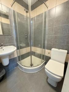 a bathroom with a shower and a toilet and a sink at Plaza Hotel in London