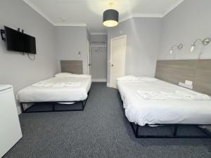 a hotel room with two beds and a flat screen tv at Plaza Hotel in London +52 photos