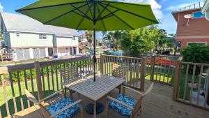 a table and chairs with an umbrella on a deck at 213 Ohio in Fort Myers Beach