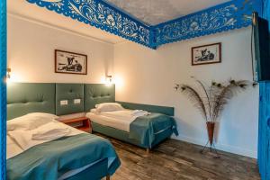 zwei Betten in einem Zimmer mit blau gestrichenen Decken in der Unterkunft Hotel Sunrise si Satul Pescaresc in Crisan + 70 Fotos