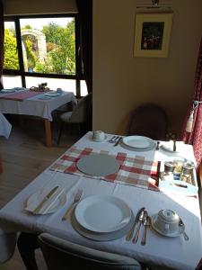 a table with plates and utensils on top of it at Oak Tree Lane Country B and B in Bridgetown