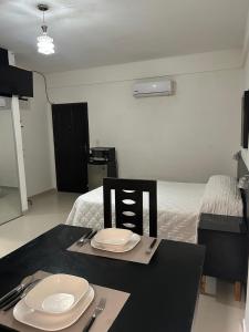 a black table with a plate and fork and knife at X5 Condominio - Diagonal a Fexpocruz in Santa Cruz de la Sierra