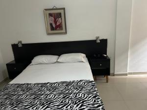 a bed with a black and white zebra print sheets at X5 Condominio - Diagonal a Fexpocruz in Santa Cruz de la Sierra