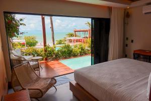 a bedroom with a bed and a view of a pool at Poozendin Hotel de Charme in Canoa Quebrada