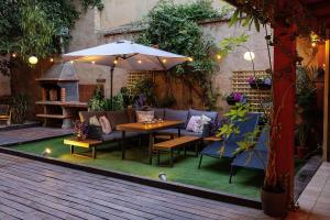an outdoor patio with a table and chairs and an umbrella at Portrait Boutique Guesthouse in Valencia +57 photos