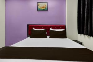 a bedroom with a large bed with a red headboard at Hotel O Visakhapatnam Railway Junction Formerly Kesava Residency in Visakhapatnam +25 photos