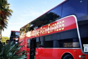 a red double decker bus driving down a street at Renaissance Orlando Resort - Disney Springs Area - Free Shuttle & Early Entry to Disney Theme Parks in Orlando