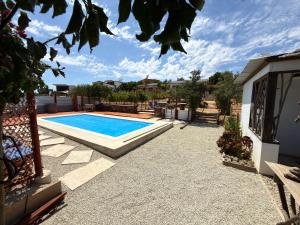 a swimming pool in a yard next to a house at Santerra, Valle de Guadalupe in Valle de Guadalupe