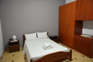 a bedroom with a bed with a wooden cabinet at Residence Rudaj in Vlorë