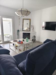 a living room with a blue couch and a table at La OSTRA 33 in Chiclana de la Frontera