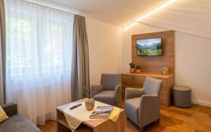 a living room with two chairs and a table at Hotel Anneliese in Bad Hindelang
