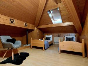a room with two beds and a chair in a attic at Casa ai Tre Colli, Tres in Tres