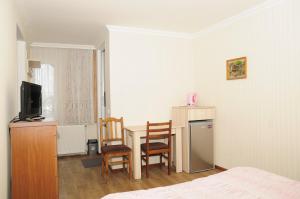 1 dormitorio con 1 cama, mesa y sillas en Grimis Villa en Borjomi