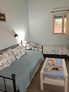 a bedroom with a bed and a table and a window at La casa di lefki in Elafonisos