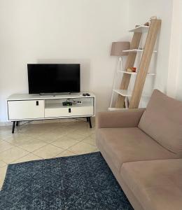 a living room with a couch and a flat screen tv at Grediv Apartment Orikum in Orikum