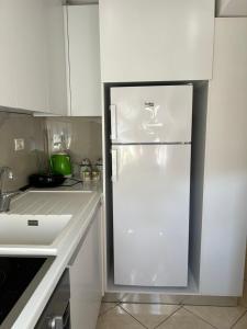 a kitchen with a white refrigerator in a kitchen at Grediv Apartment Orikum in Orikum