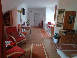 a living room with red chairs and a table at Pasager House in Sovata
