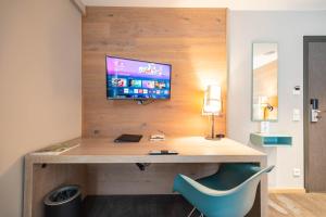 a desk with a monitor and a blue chair at Berliner Hof Bed&Bike in Saint-Vith