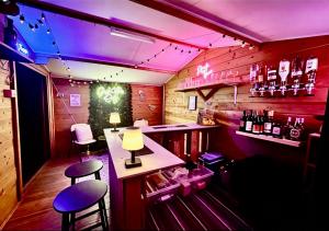 a bar with two stools and a counter with purple lights at The Natures Nook With HotTub in Talog
