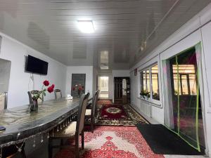 a dining room with a long table and chairs at Archa Ethno Guest House in Bokonbayevo