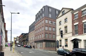 a building on a city street with cars parked at Hütel in Liverpool
