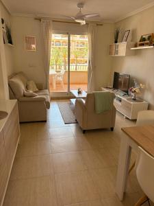 a living room with a couch and chairs and a television at Mar de Cristal in Mar de Cristal