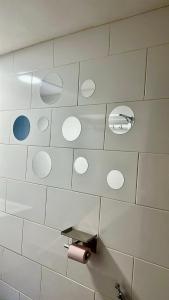 a tiled bathroom with a toilet paper holder and a mirror at Chez Misto in Ouangani +41 photos