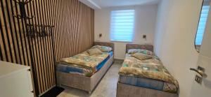 a bedroom with two beds and a window at Apartmán U našich in Jeseník
