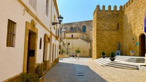 an alley in a castle with people walking down it at La Terraza del Castillo- Playa de Rota in Rota