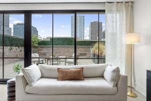 a living room with a couch and a large window at The Theodore New Orleans in New Orleans