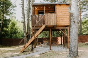 a tree house in the woods with chairs in it at Tesla`s Valley in Smiljan