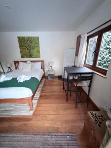 a bedroom with a bed and a desk and a table at The Natures Nook With HotTub in Talog