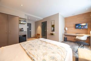 a bedroom with a large bed and a desk in it at Berliner Hof Bed&Bike in Saint-Vith