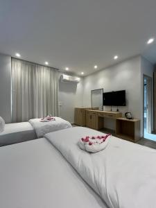 a bedroom with two beds and a flat screen tv at Saqqara Pyramids view Hotel in Cairo