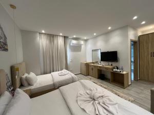 a hotel room with two beds and a flat screen tv at Saqqara Pyramids view Hotel in Cairo