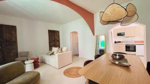 a living room with a wooden table and a kitchen at Appartement arche centre historique in Narbonne