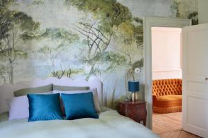 a bedroom with a bed with a painting on the wall at Demeure Les ragottières in Le Plessis
