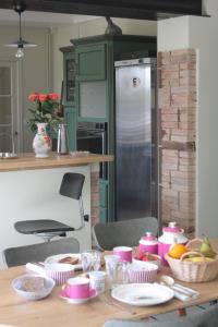 a kitchen with a table with plates and bowls at Demeure Les ragottières in Le Plessis +29 photos