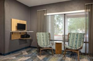 a room with two chairs and a table and a television at SpringHill Suites by Marriott - Tampa Brandon in Tampa