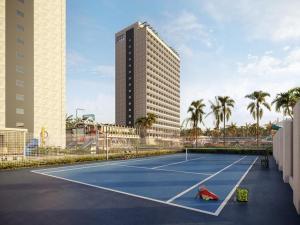 a tennis court in front of a tall building at Apartamento Beach Resort in Salinópolis +6 photos
