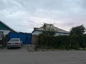a car parked in a driveway next to a house at NurNomad 2 in Balykchy