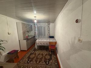 a small room with a table and a kitchen at NurNomad 2 in Balykchy