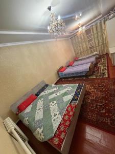 a bedroom with two beds and a chandelier at NurNomad 2 in Balykchy