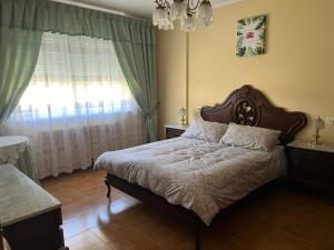 a bedroom with a large bed and a window at Casa Ezaro in Dumbría +2 photos