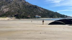 a group of people walking on a beach at Casa Ezaro in Dumbría