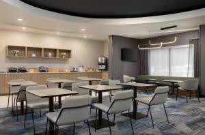 a dining room with tables and chairs and a kitchen at SpringHill Suites by Marriott - Tampa Brandon in Tampa