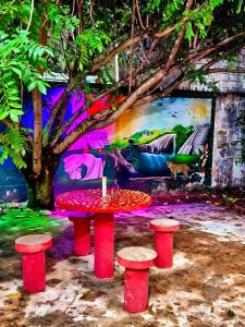 a table and two stools in front of a painting at Departamento Refugio Verde in Palenque