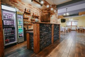 a bar in a restaurant with a brick wall at Grádics Panzió in Siculeni