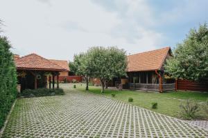 an image of a house with a cobblestone driveway at Grádics Panzió in Siculeni